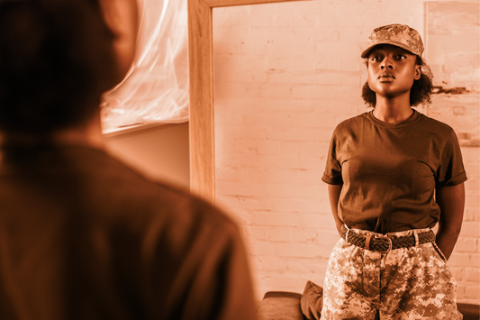 Woman dressed in military clothes looking at herself in the mirror